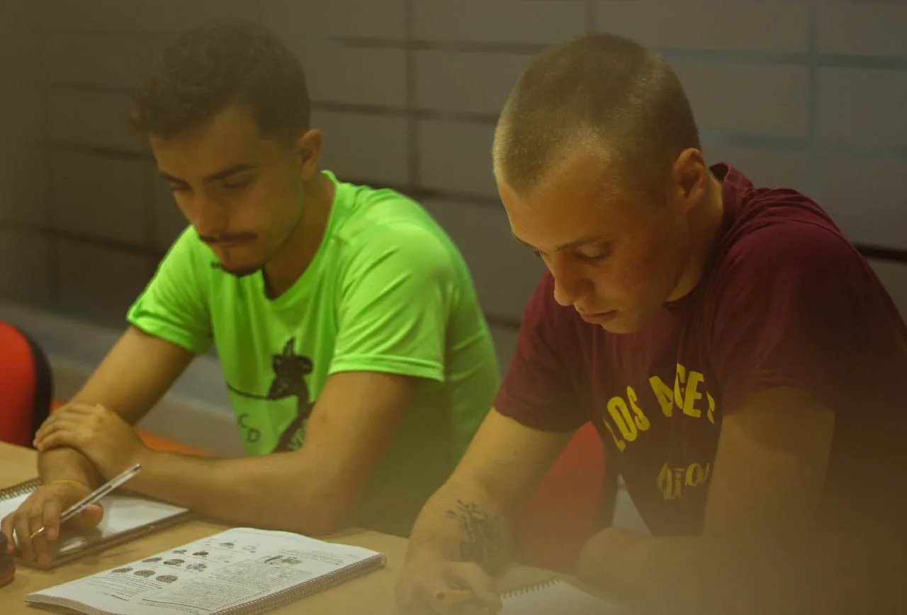 Estudiantes en un curso de inglés en la mejor academia interactuando durante la clase.