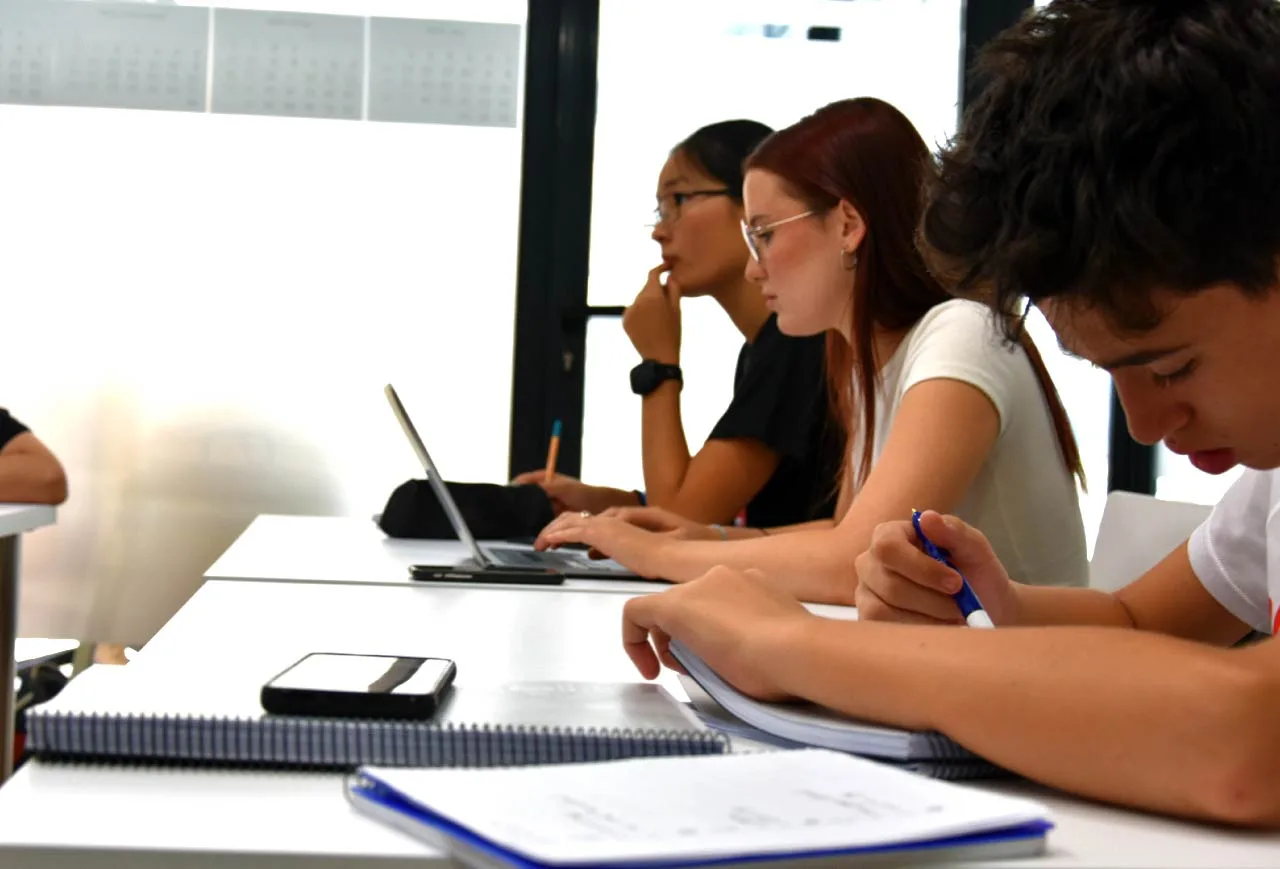 Grupo de estudiantes colaborando durante una clase en nuestra academia de inglés.